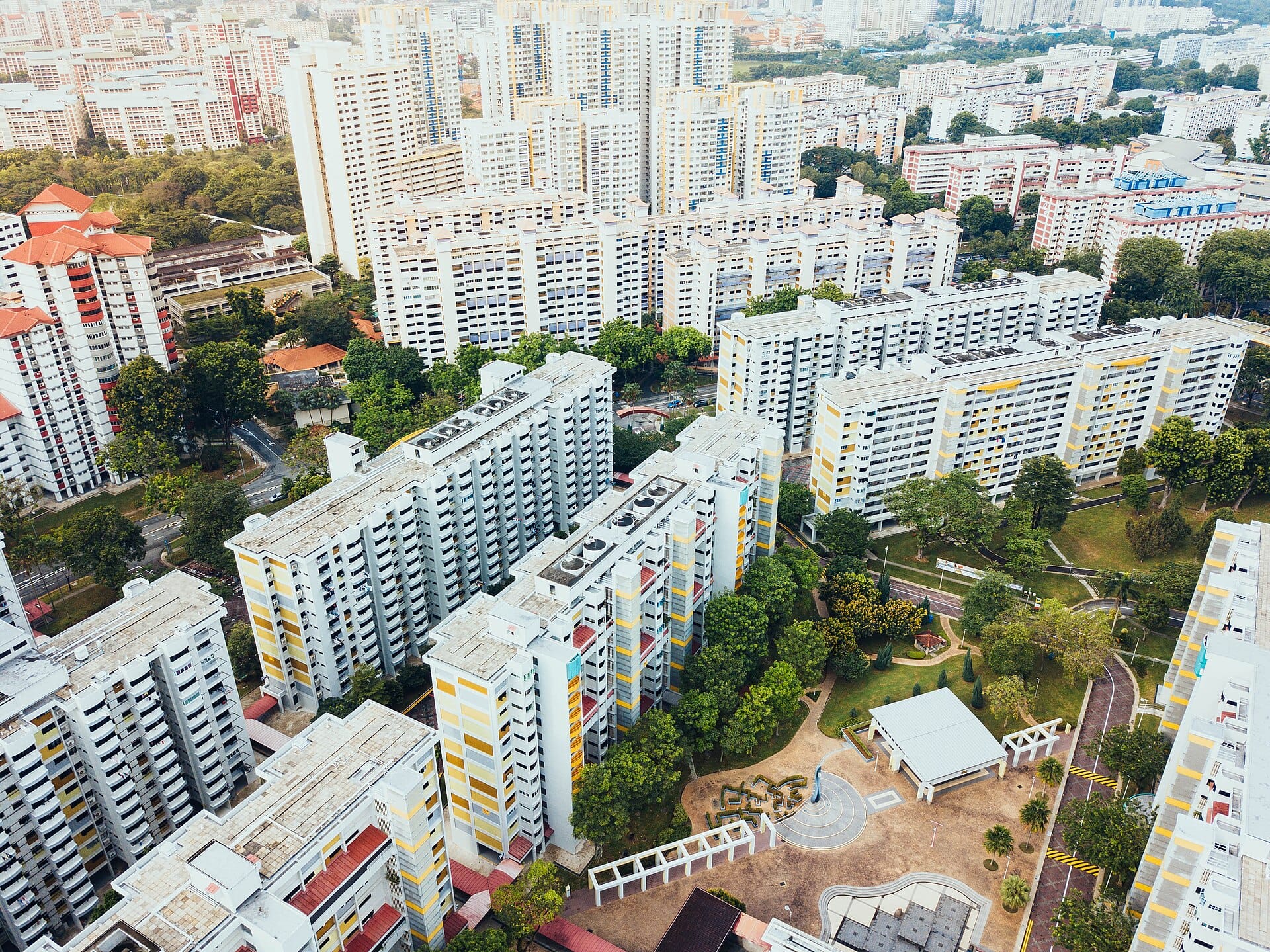 Cluster of apartment buildings surrounded by trees with text, "ANG MO KIO" and "START YOUR JOURNEY" on the right side.